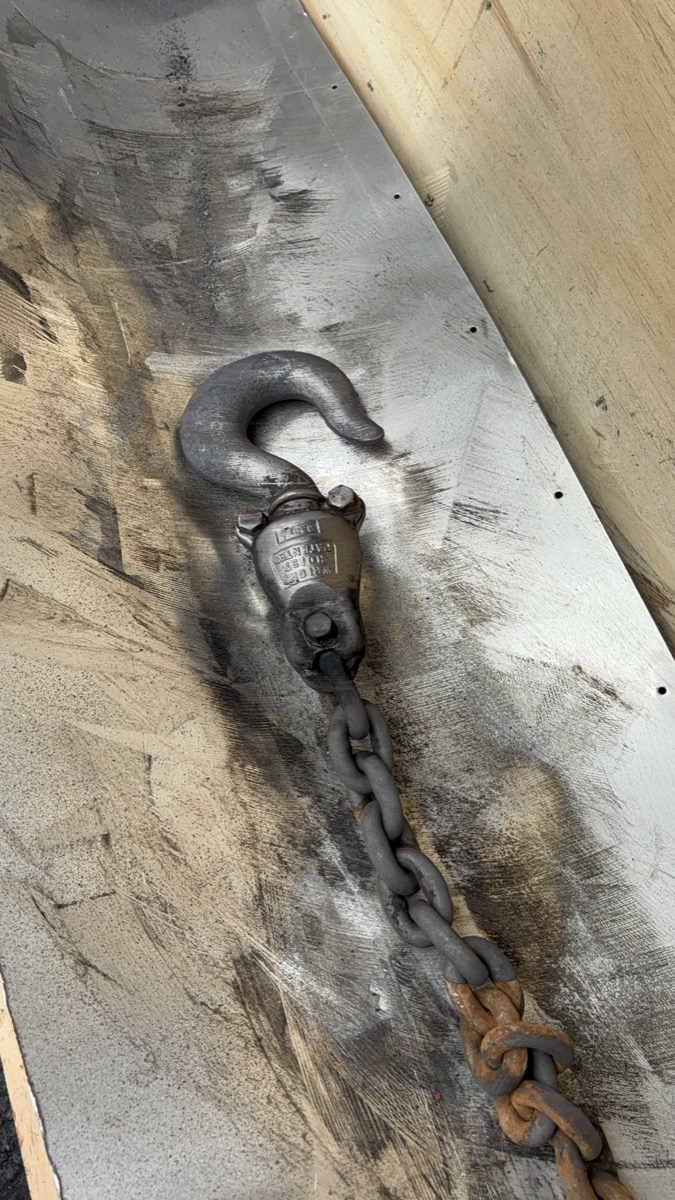 Wright hoist hook partially cleaned — laser cleaning in progress